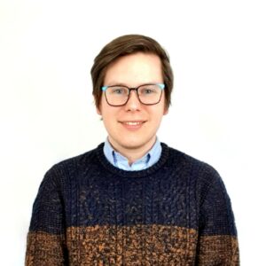 About us - Cameron, the founder, smiling in a dark blue and burnt orange jumper